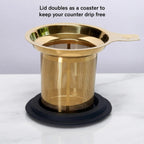 Gold tea infuser resting on silicone lid