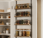 Four visible storage baskets on an over-the-door pantry rack in a bright kitchen