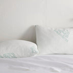 Adjustable bamboo cooling pillow pair on a white bed